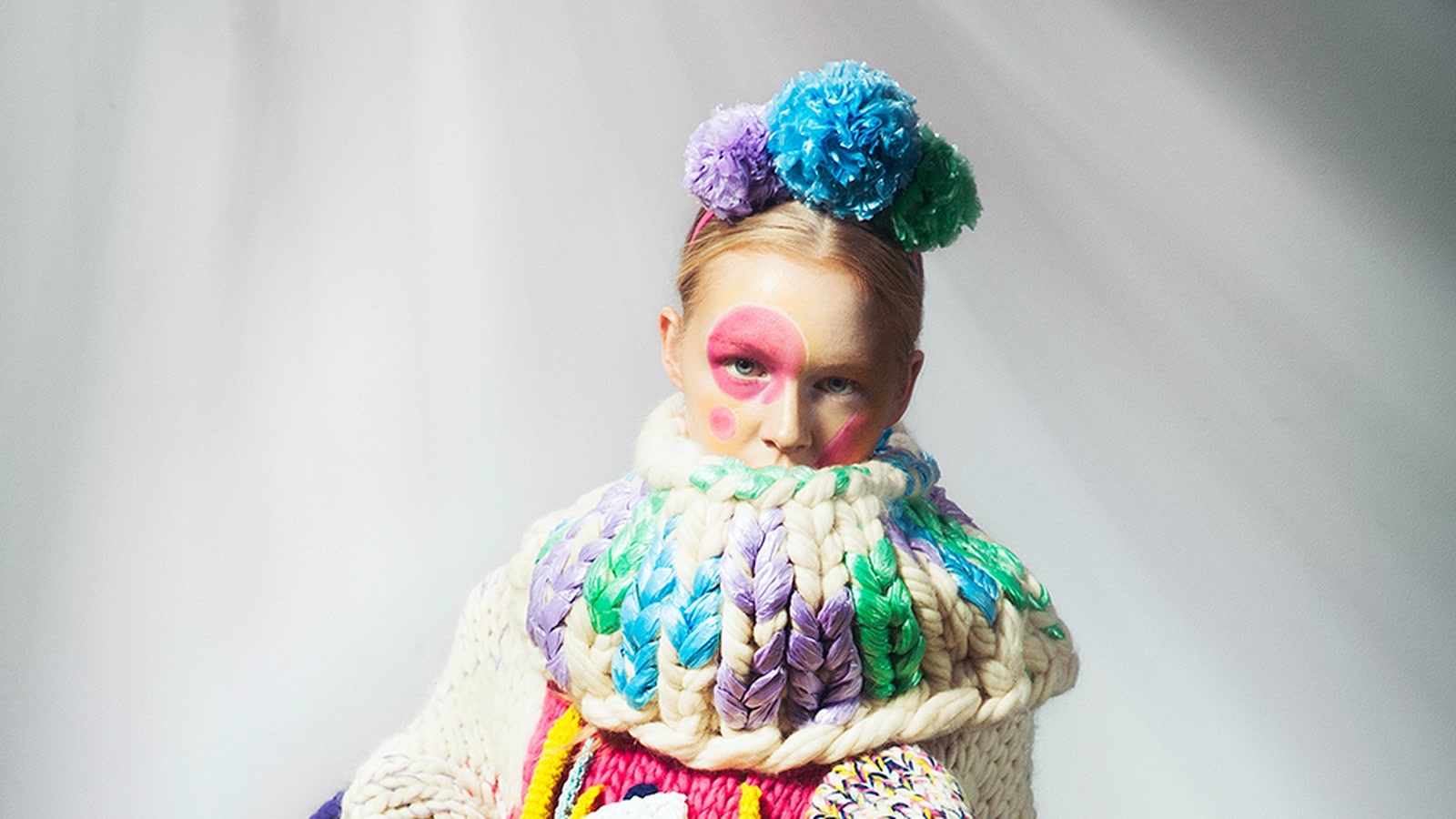 Modella incorniciata da un collo scultoreo multicolore con maglie di grande scala