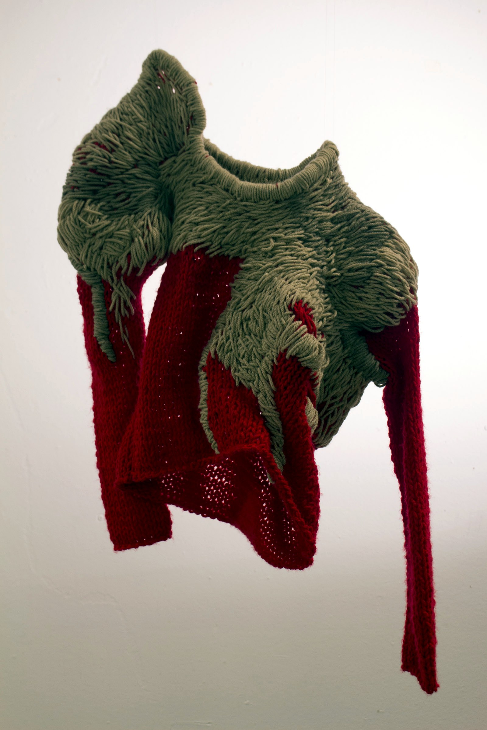 Archive image of a sculptural loop-knit garment over a red knit ground